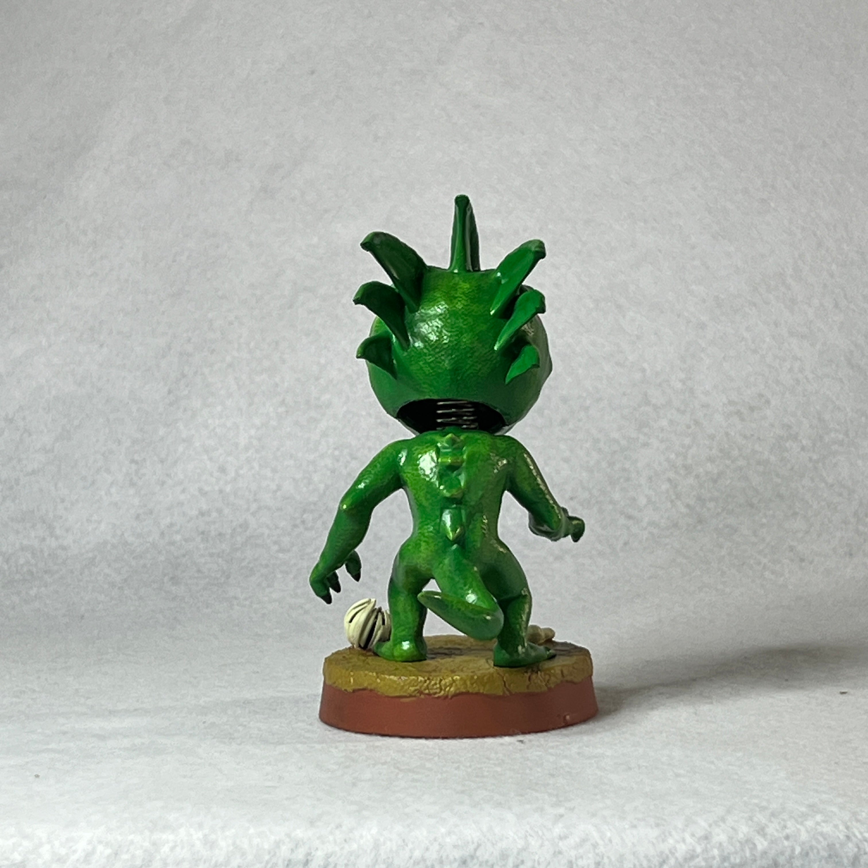 Green figurine on a white background