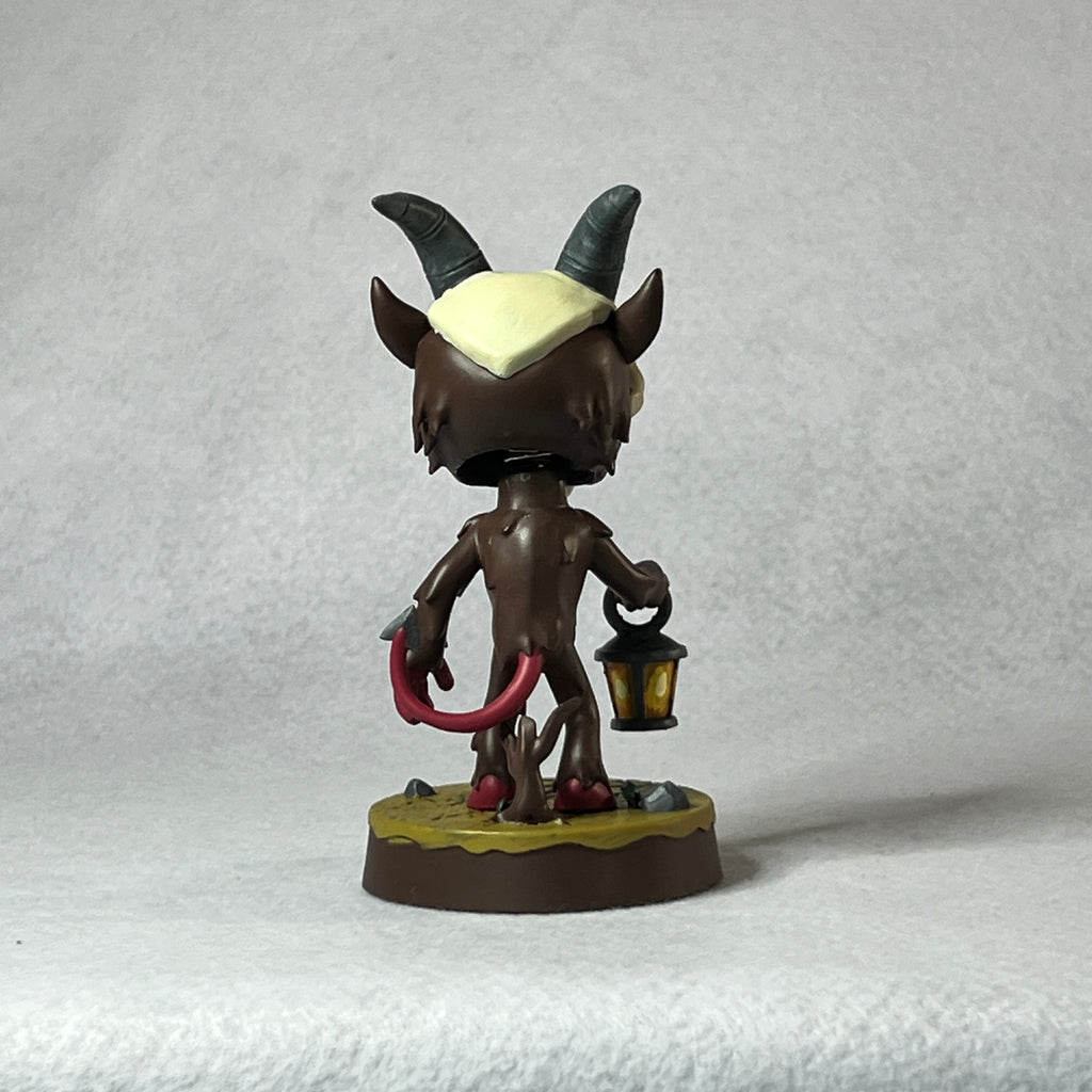 Figurine with horns and a lantern on a textured gray background
